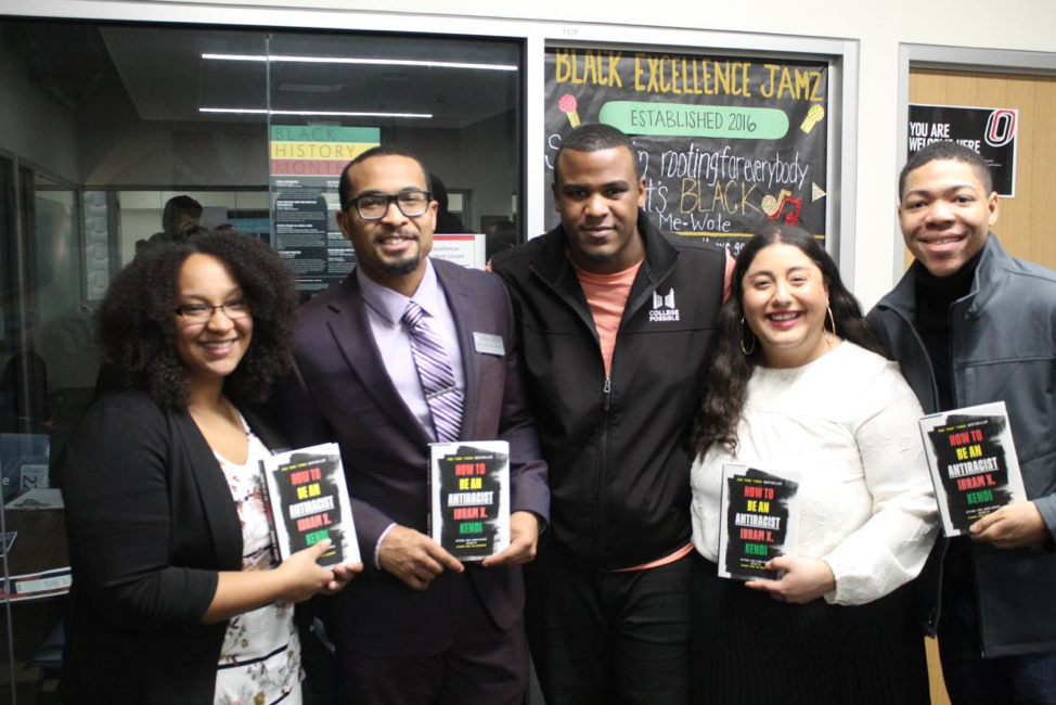 Organizers and attendees pose with Kendi’s book after a meet-and-greet with the author at UNO.